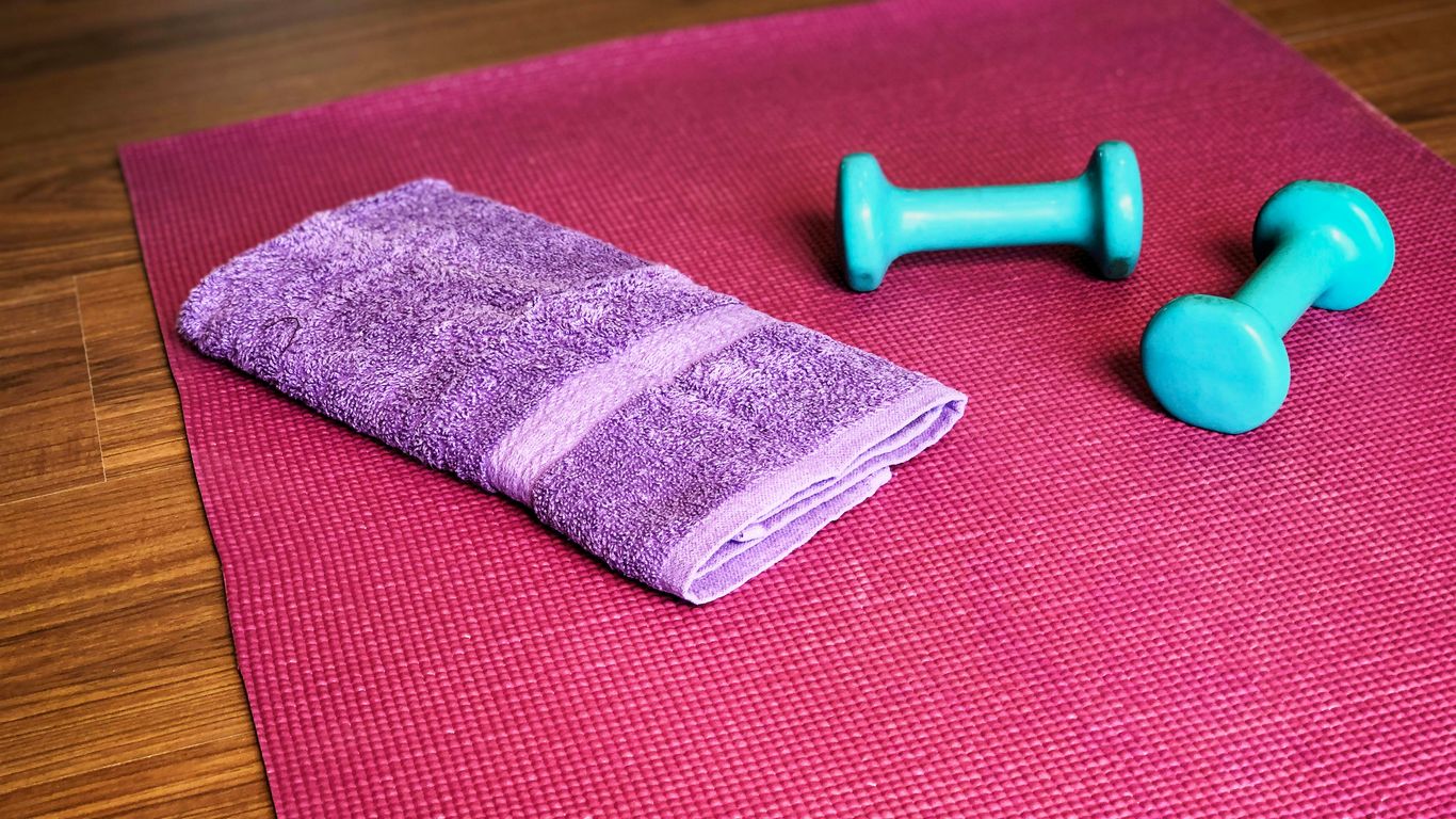 Yoga mat, weights, and a towel ready for a workout.