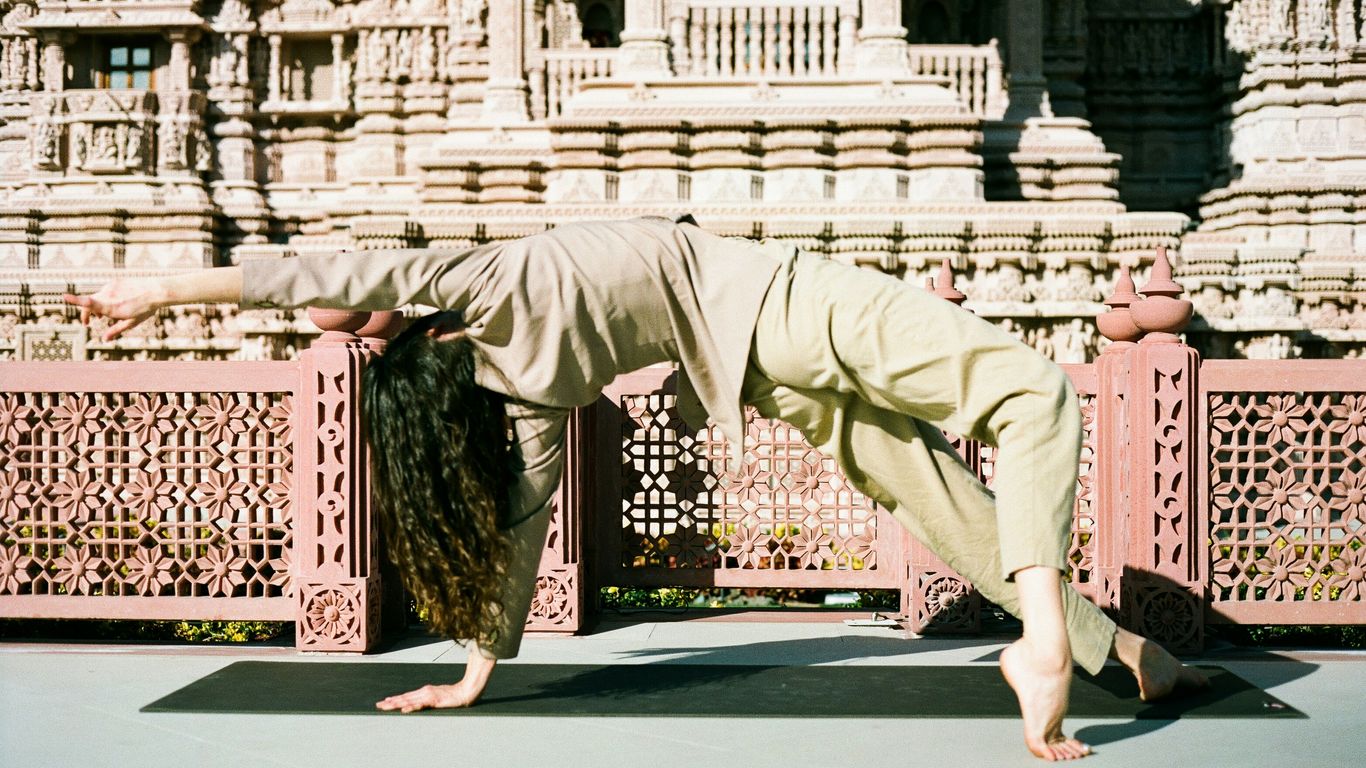 A person doing a yoga pose in front of a building