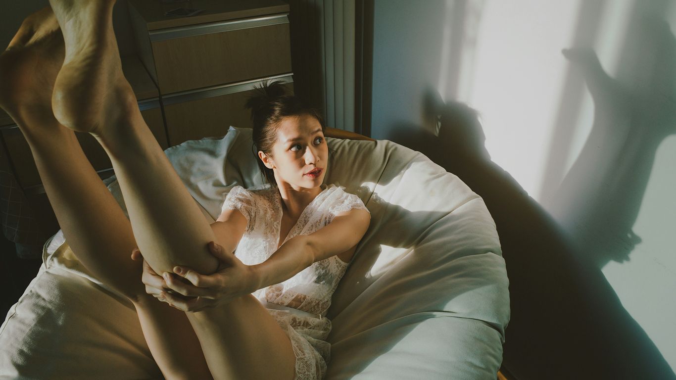 a woman laying in bed with her legs spread out