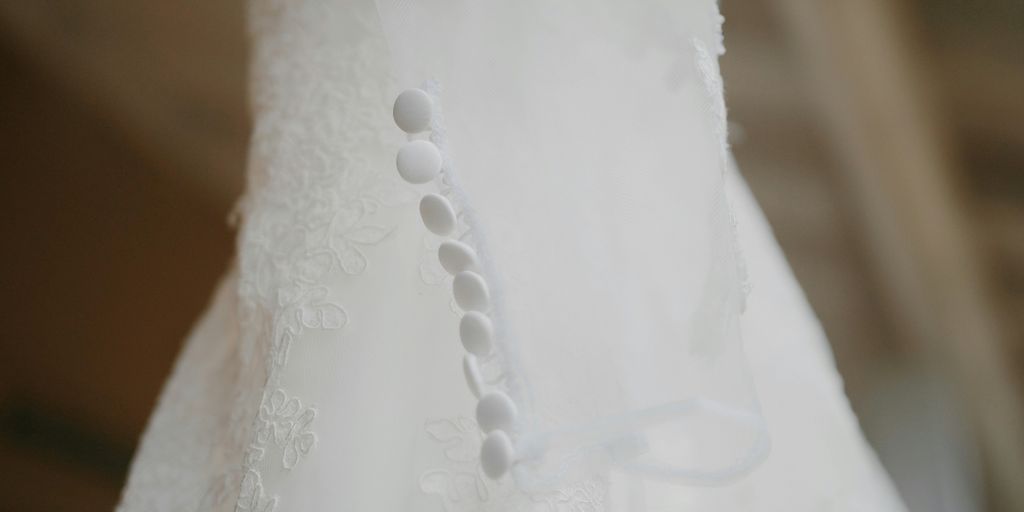 a close up of a white dress with beads on it