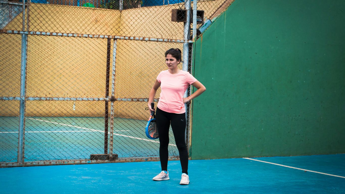 a woman standing on a tennis court holding a racquet