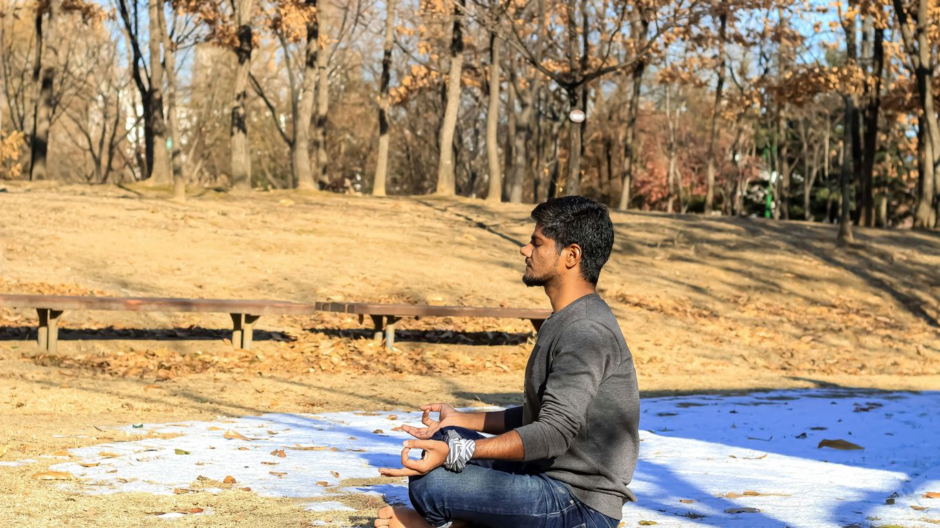 a man sitting on the ground in a park