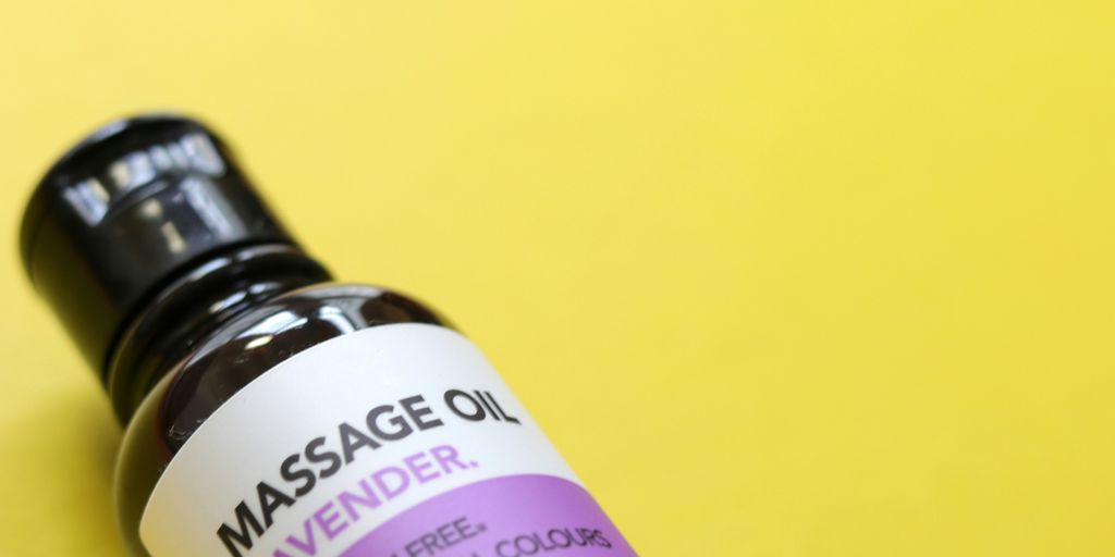 a bottle of massage oil sitting on a yellow surface