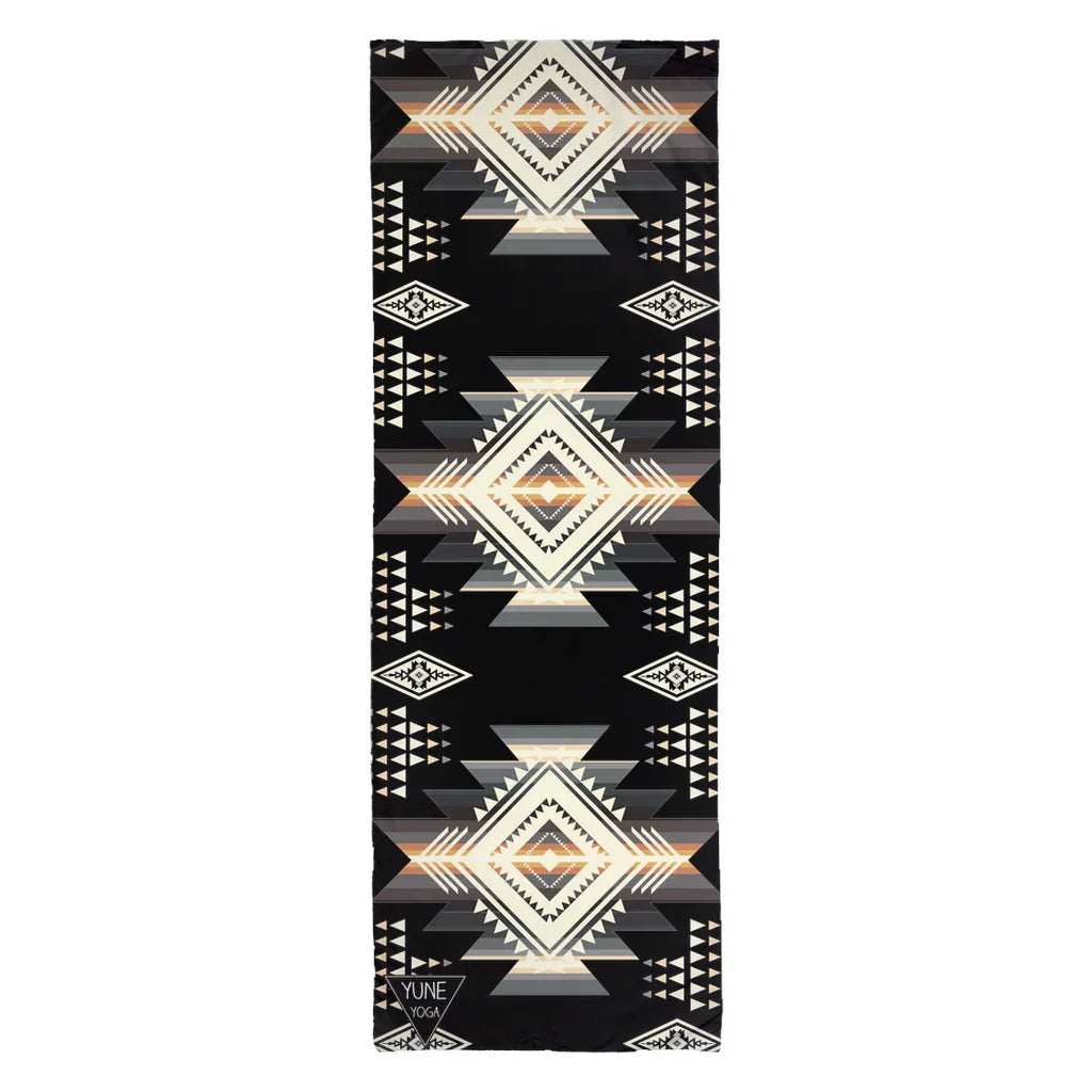 Yoga mat with black background and geometric tribal patterns in beige and brown tones
