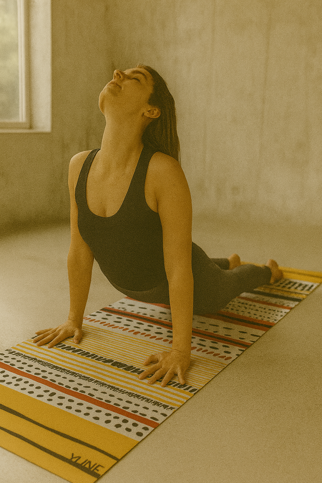Woman practicing yoga on a striped mat in a room with a window.