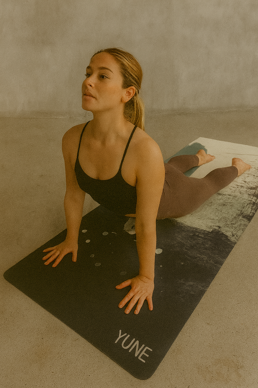 Woman practicing yoga on a Yune mat in a minimalistic setting