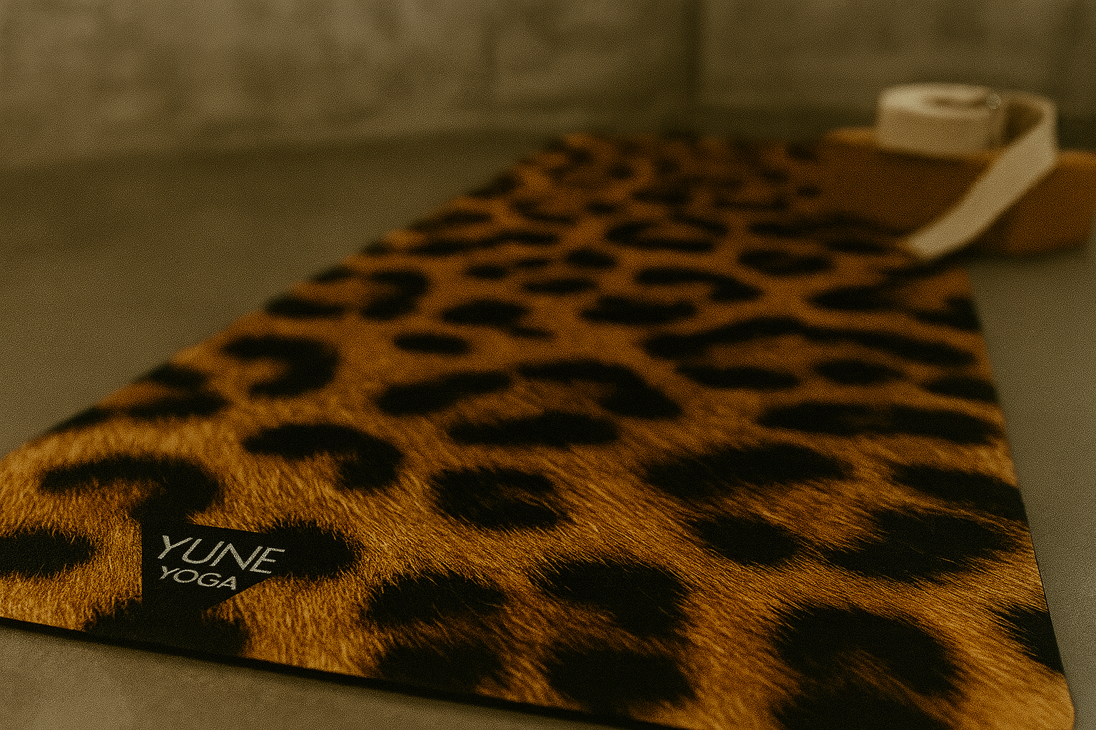 Leopard print yoga mat with 'YUNE YOGA' branding on a neutral background