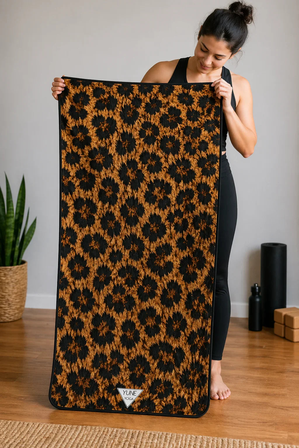 Woman holding leopard print yoga mat in minimalist studio with wooden floor