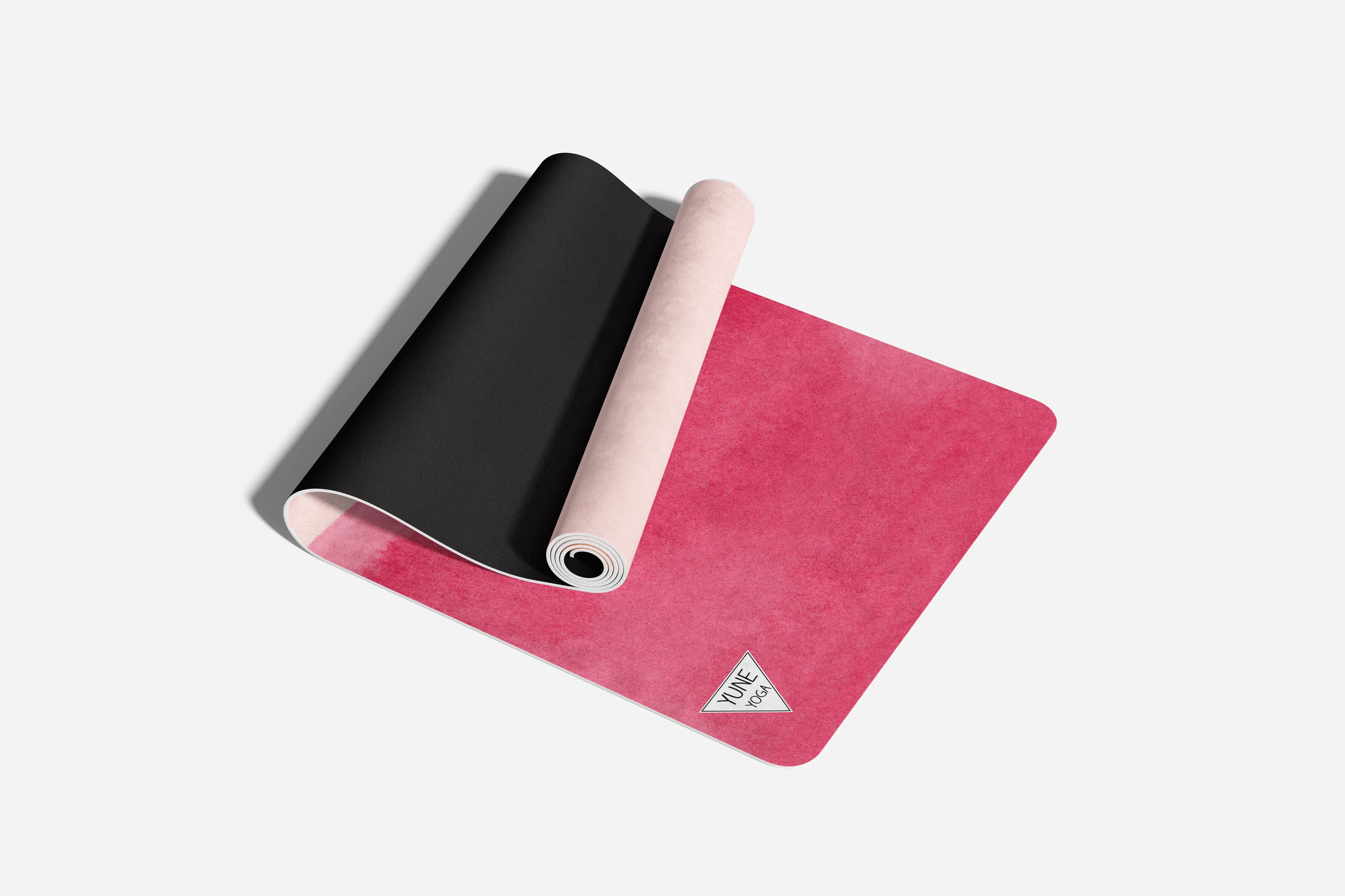 Pink and black yoga mats on a white background