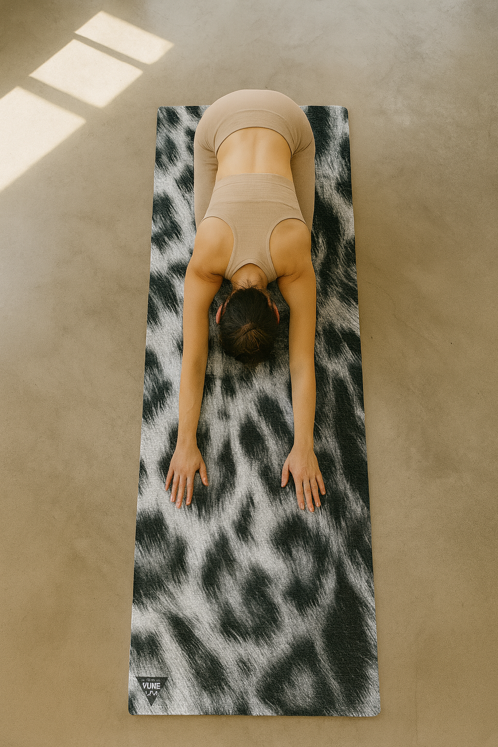 Person practicing yoga on a leopard print mat in a sunlit room