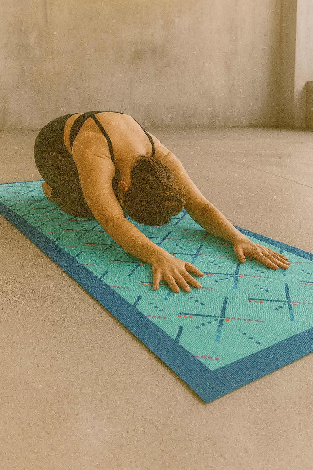 Person practicing yoga on a textured mat with a neutral background