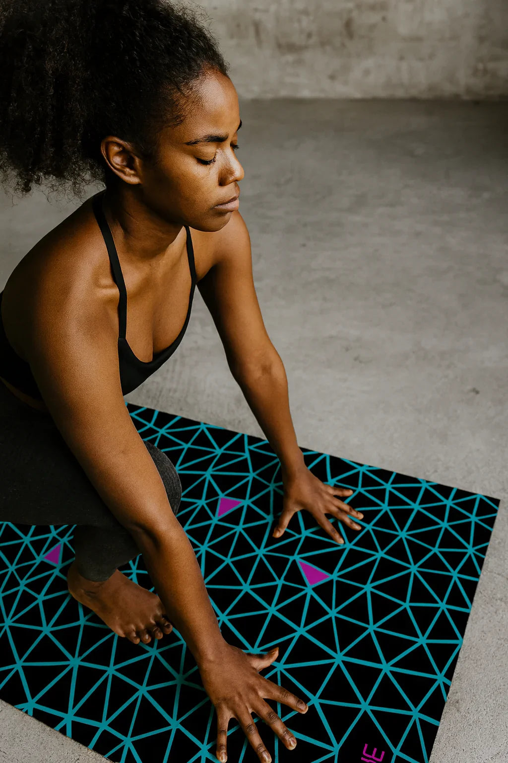 Person on a geometric-patterned yoga mat in a minimalistic setting