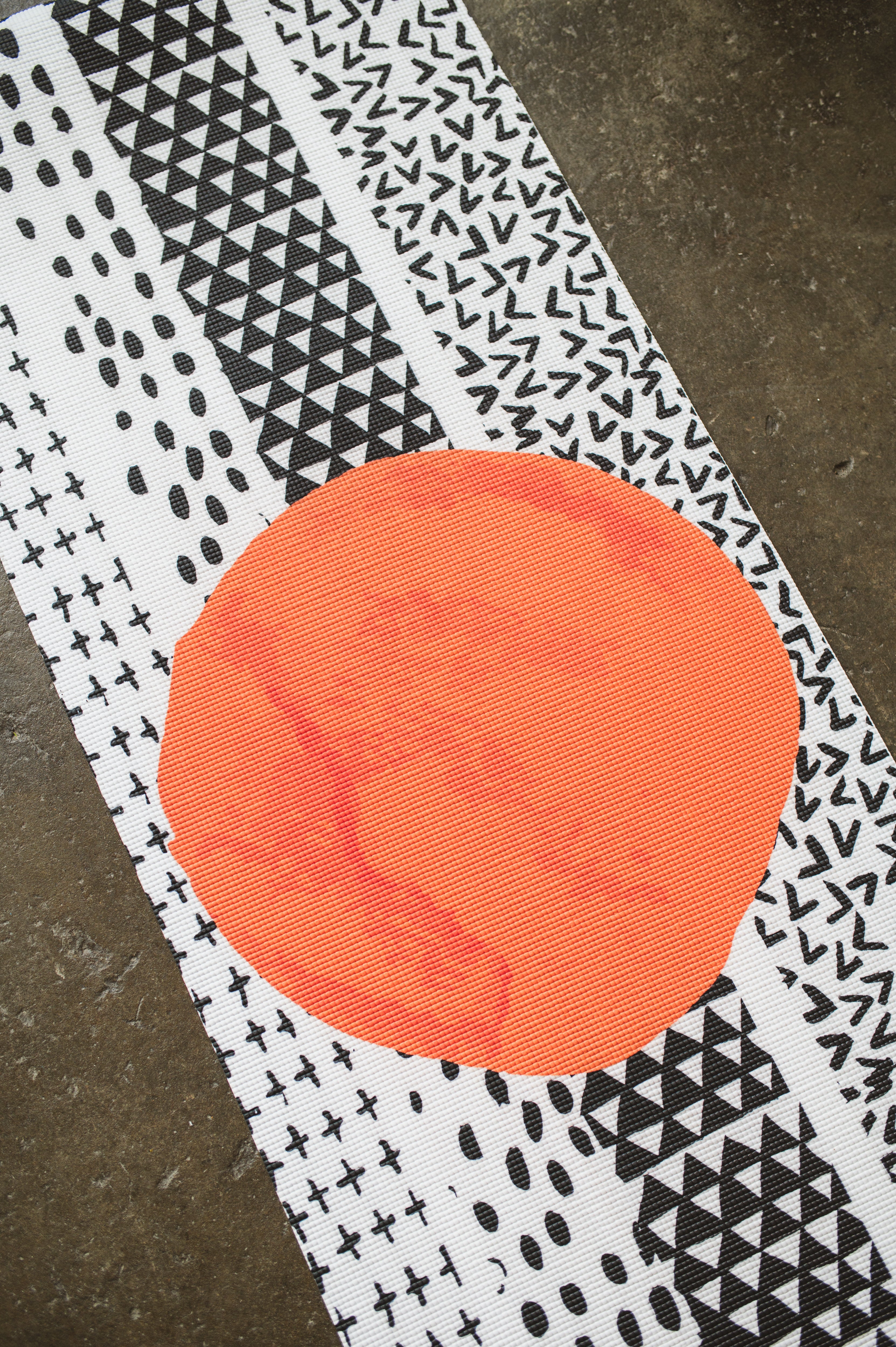 Textile with orange circle and black and white pattern