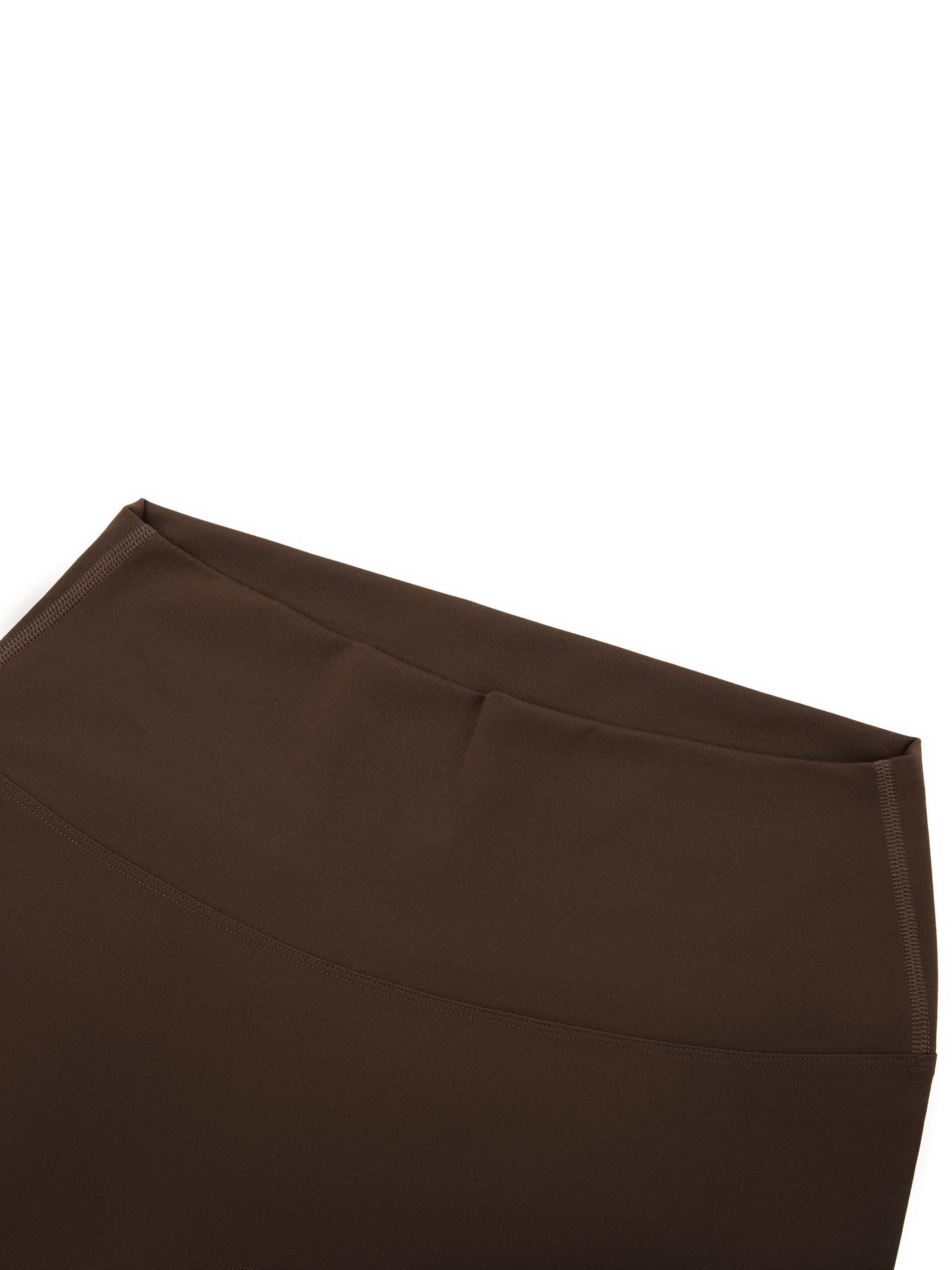 Close-up of brown yoga leggings waistband on white background
