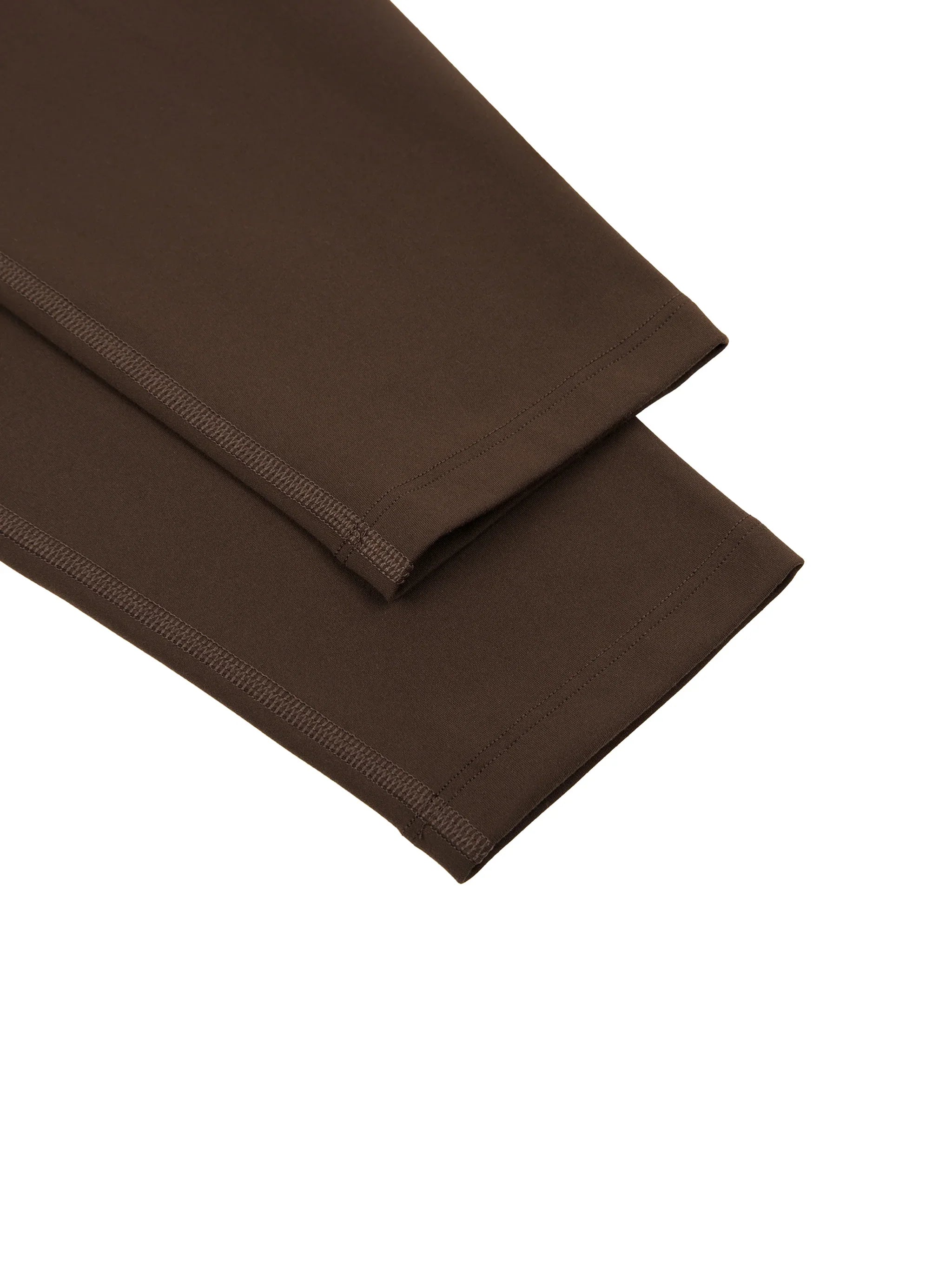 Close-up of brown yoga leggings fabric and hem detail on white background