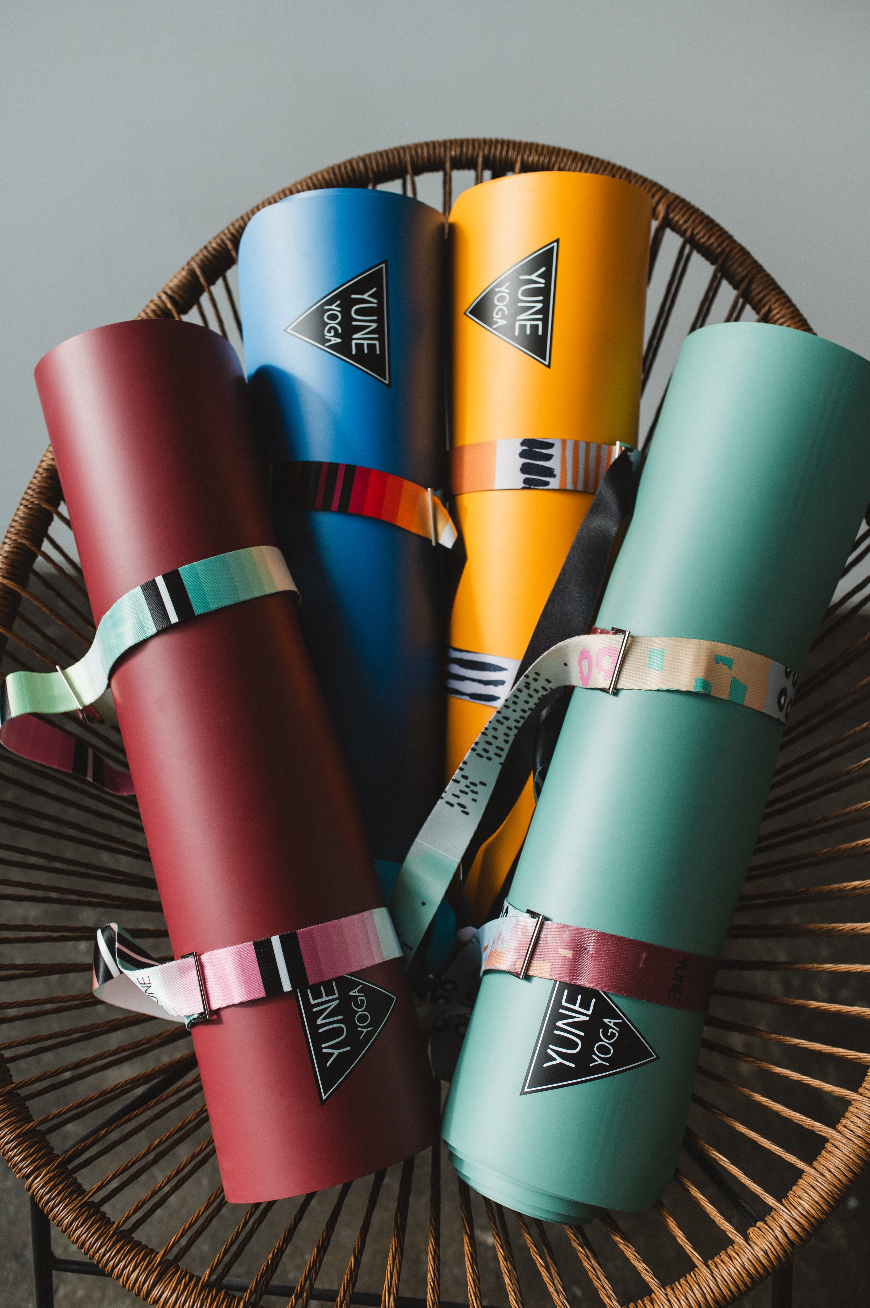 Four colorful yoga mats with 'Yume Yoga' branding on a woven mat.