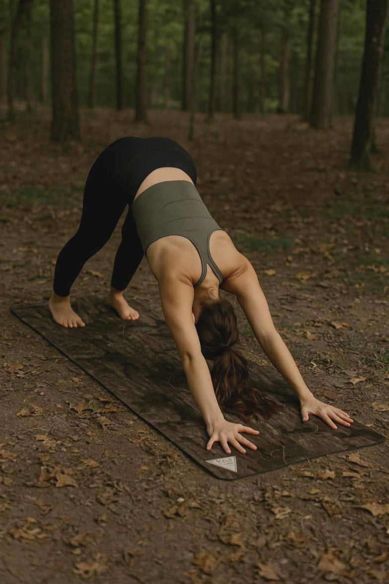 woman in the forest doing yoga on a camo yoga mat