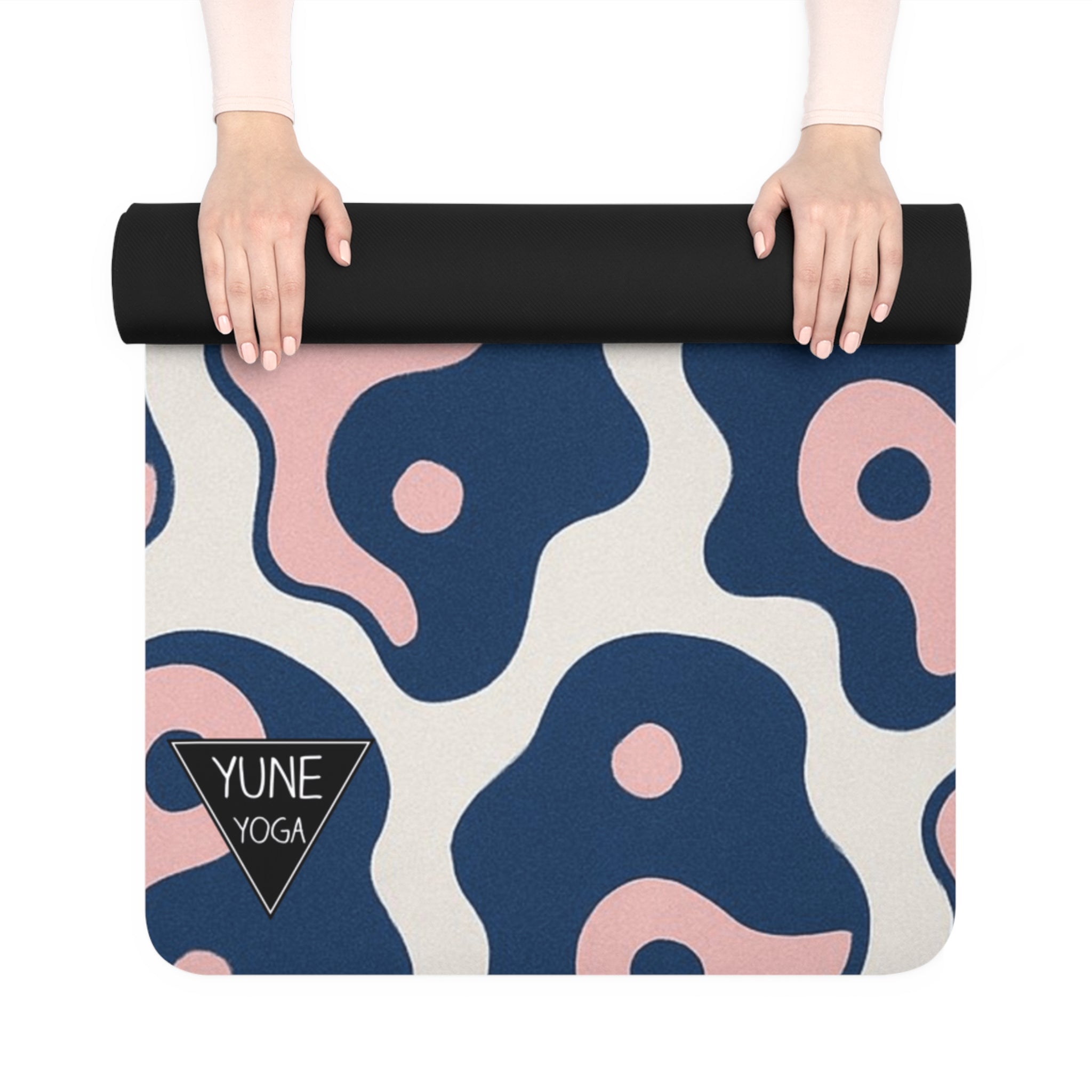 Yoga mat with abstract pattern and Yune Yoga logo held by hands on a white background